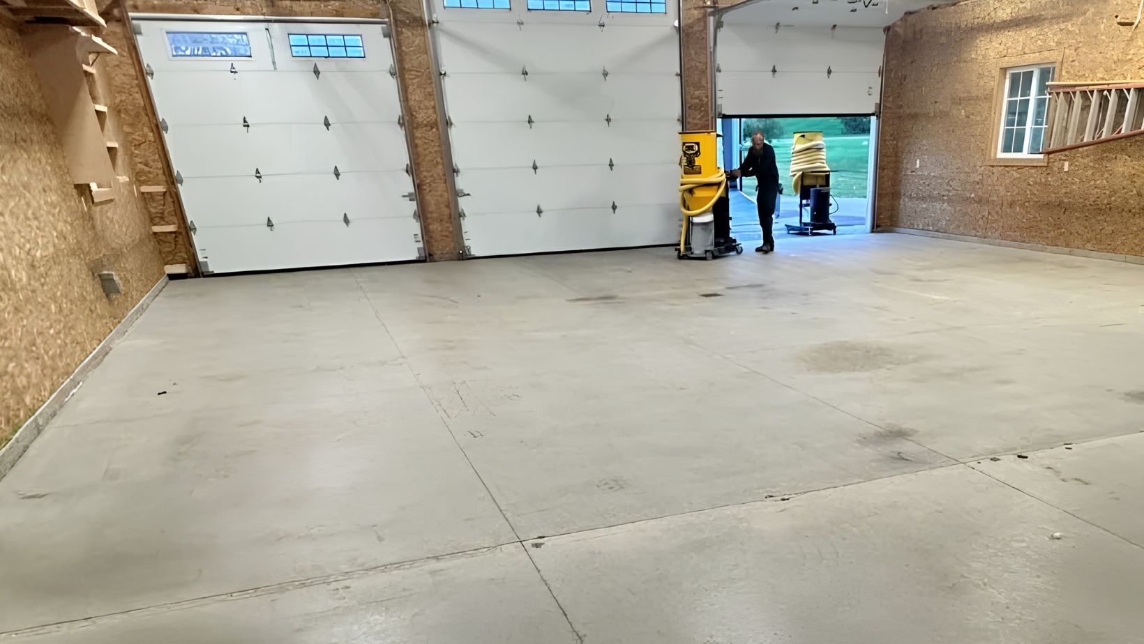 Rough bare concrete in a large pole-barn garage before a High Caliber coating