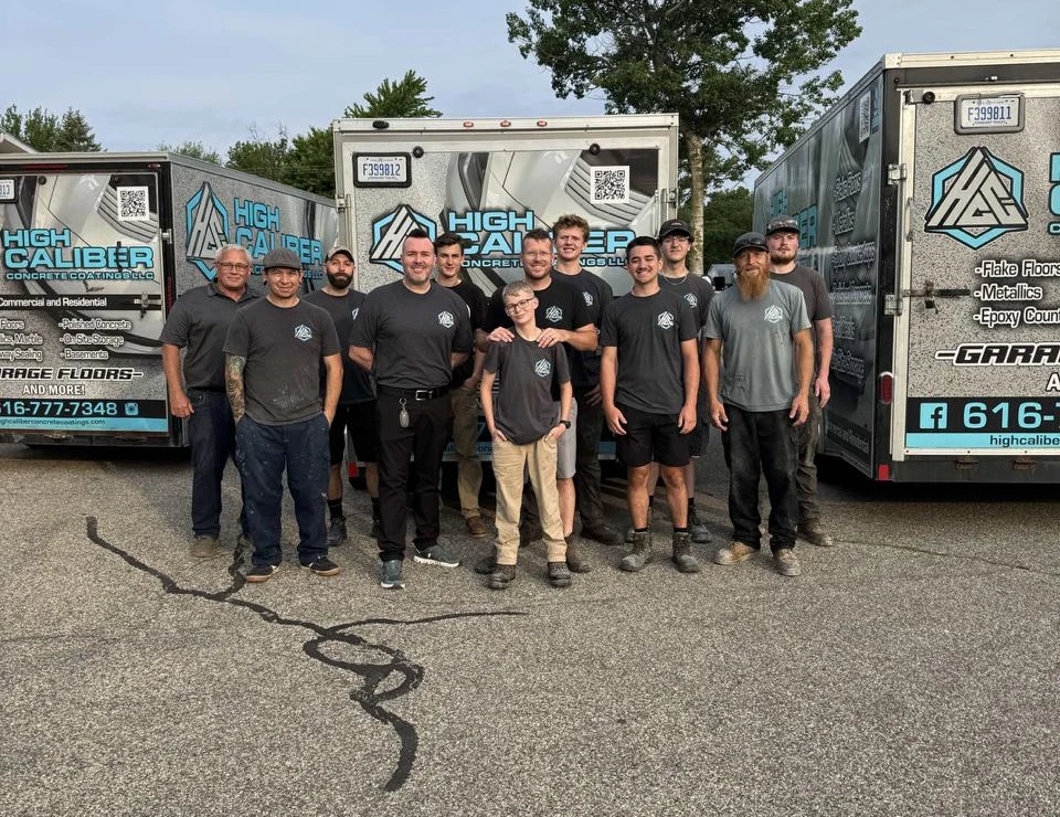 The High Caliber Concrete Coatings team standing between branded work trailers